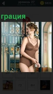 Девушка около окна грация в изящном купальнике, привлекая мужские взгляды и радуя глаза