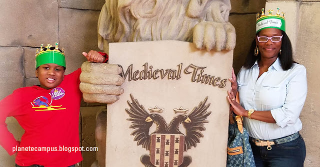 Kidada and her son pose smiling with a "Medieval Times" sign at a recent family birthday celebration.