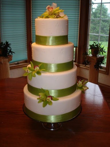 Round four tier wedding cake with green ribbon around the base of each tier 