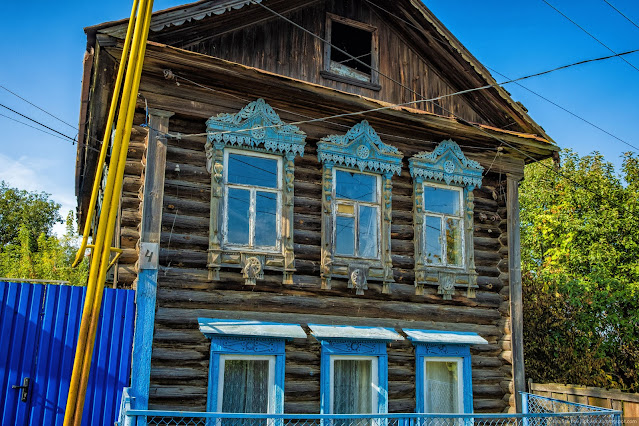 Старый двухэтажный дом с голубыми наличниками