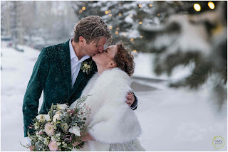 bride and groom kissing for a photo on a snowy winter day in breckenridge colorado mountains