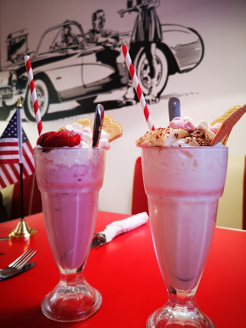Two pink milkshakes in glasses on the table at Lily's American Diner in Folkestone