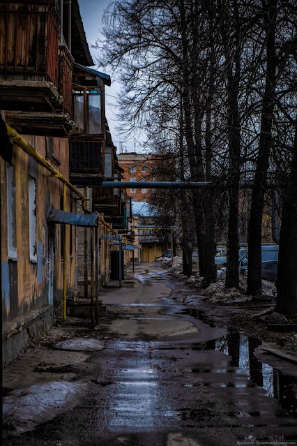 Улочка в лужах вдоль жилых домов