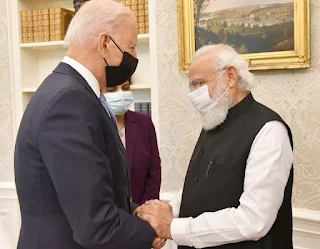 Prime Minister Narendra Modi and President Joe Biden shaking hands and smiling