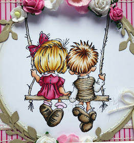 Shaped pink card with couple on swing (image from LOTV)