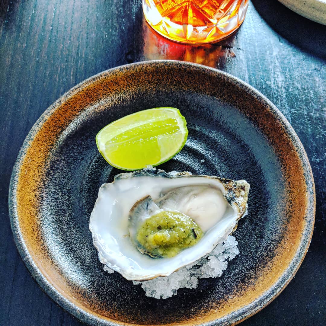 oyster with wedge of lime of pretty plate at cornerstone in hackney wick london