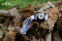 A LED Lenser SEO 5 headlamp sitting on a rock.