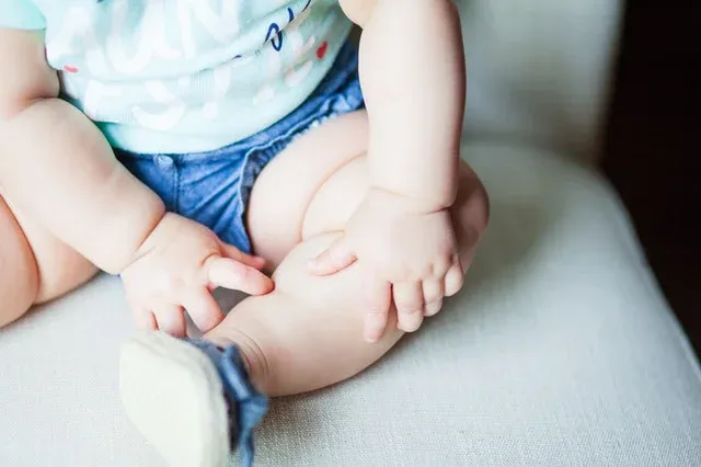 Sitting baby with arms and legs showing