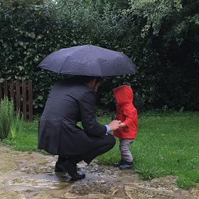 petit garçon et son papa sous la pluie