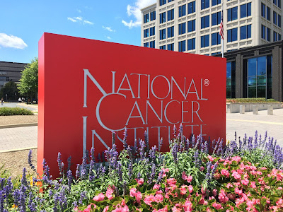 sign in from of building that reads "National Cancer Institute"