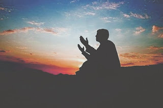 Seorang ahli ibadah yang bersimpuh dengan tulus, mengangkat tangan dalam doa penuh keikhlasan