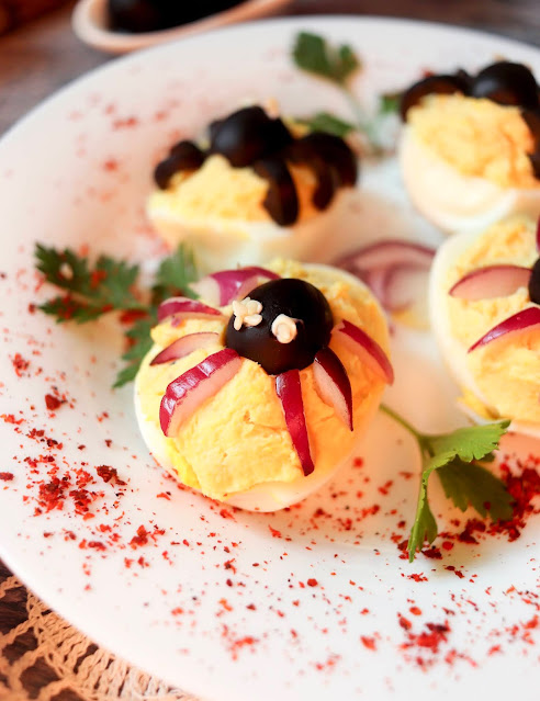 close up of spider deviled egg on a plate.