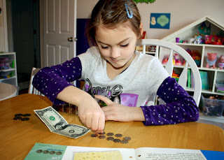 Tessa identified various paper bills and their worth. She also counted out the proper number of coins to equal a dollar.