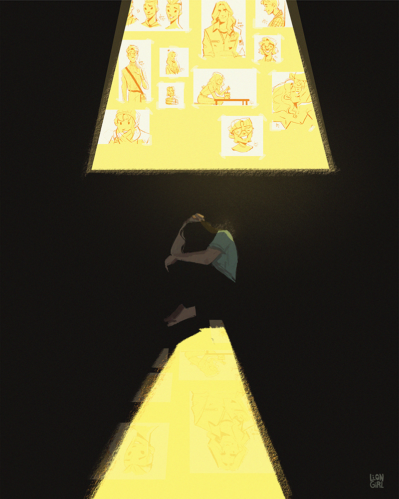 An artist sits on the floor curled into himself surrounded by darkness. A triangular yellow light shines above him to show a wall of drawings of happy characters
