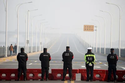 Os policiais vigiam o posto de controle localizado na ponte do rio Jiujiang Yangtze, na região de Hubei. Foto: REUTERS / Thomas Peter -