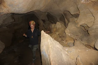 Danielle in a cave tunnel with rock formations