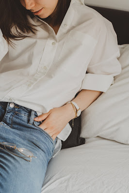 Mujer con vaqueros y una camisa blanca arremangada