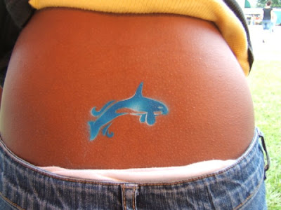 Blue small dolphin lower back tattoo. Blue small dolphin lower back tattoo.