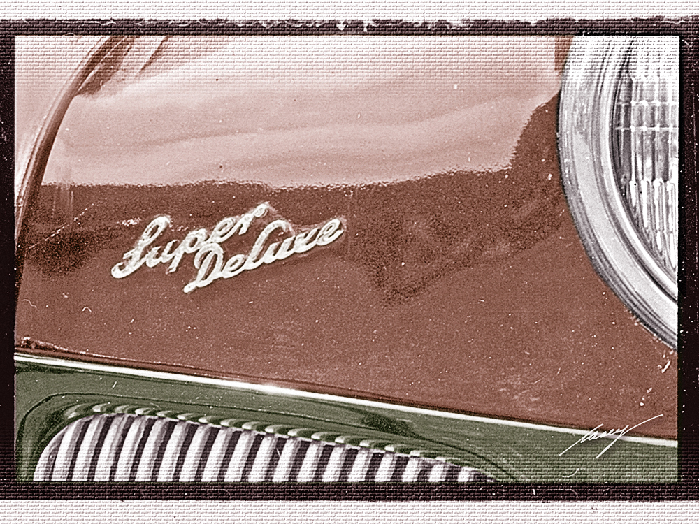 The Super Deluxe script nameplate on the front of a 1941 Ford