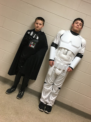 Two boys, one dressed as Darth Vadar and one dressed as a Storm Trooper
