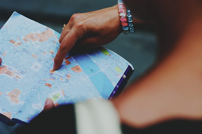 A person points to a map in a guidebook.