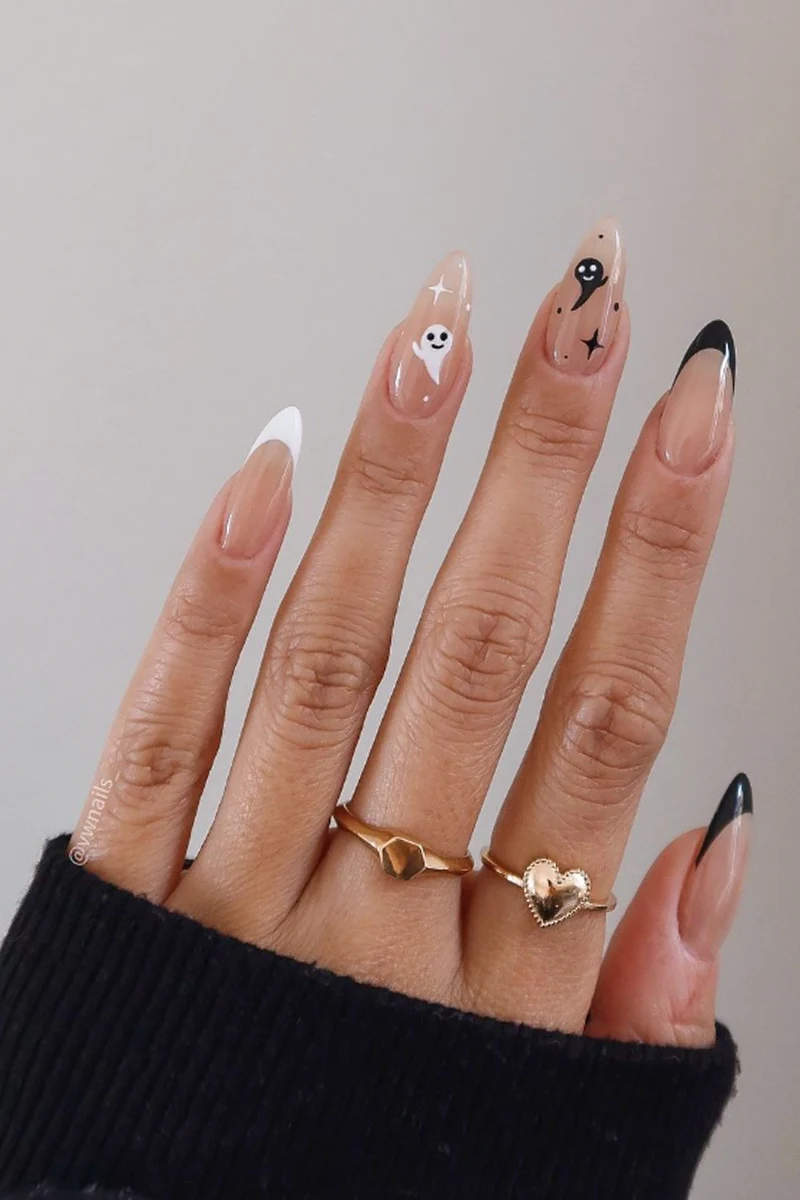 close-up of woman hand with a very cute and minimal halloween nail design with ghosts