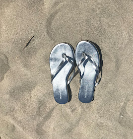 silver Melissa flip flops on the sand 