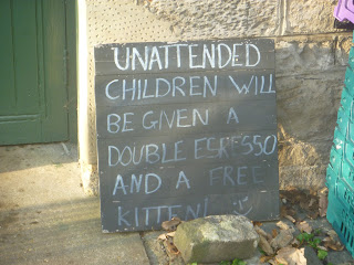 A chalkboard with the message Unaccompanied Children will be given a double espresso and a free kitten