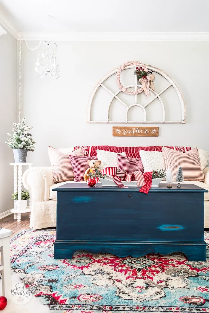 white sofa, red pillows, antique window and Christmas wreath