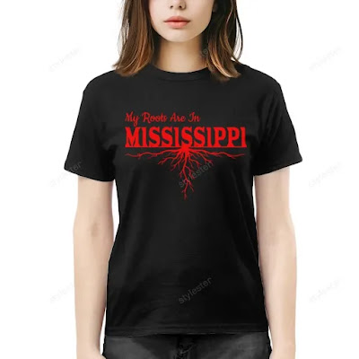 Woman wearing a black t-shirt with red "My Roots Are In Mississippi" design featuring a tree root graphic