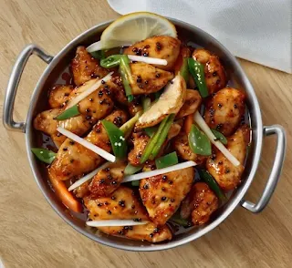 Spicy Black Pepper Chicken Karahi served in a traditional wok, garnished with fresh cilantro, mint, and lemon wedges, ready to be enjoyed.