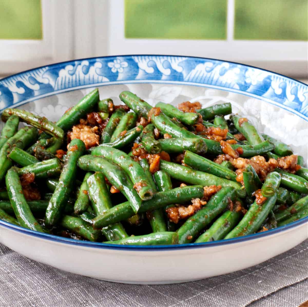 Dry-Fried Sichuan Beans in a blue trimmed bowl.