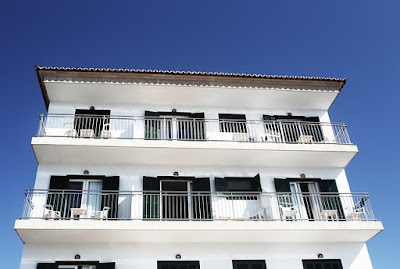 Une maison blanche avec des garde-corps tout le long de ses terrasses.