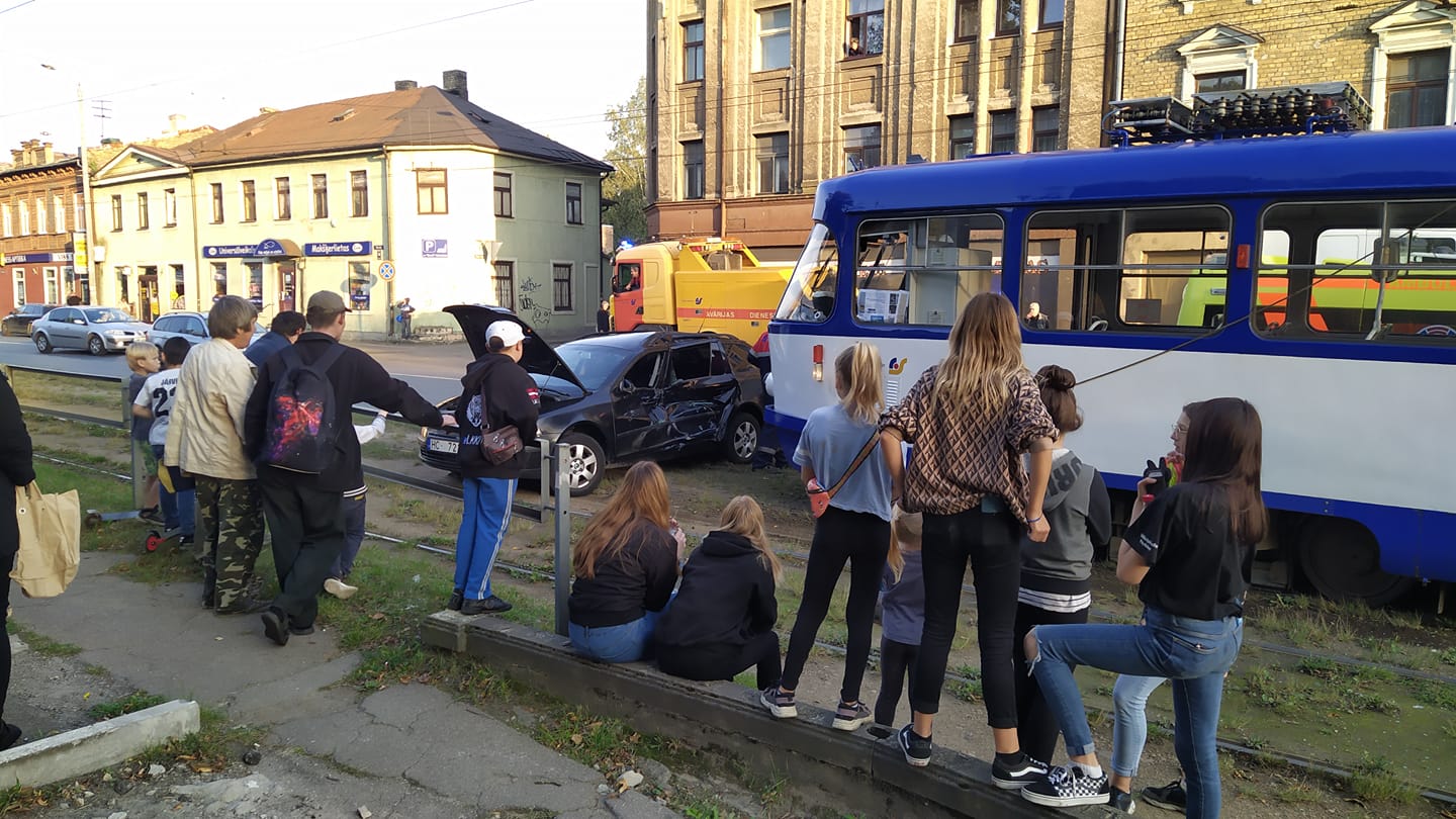 Cilvēki vēro tramvaja un vieglā auto avārijas sekas