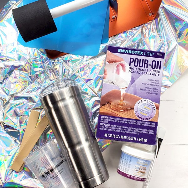 SUPPLIES NEEDED FOR IRIDESCENT RESIN TUMBLER: Stainless Steel Tumbler Envirotex Lite High Gloss Finish Iridescent Table Cloth from Dollar Store Ultra Seal Paintbrush Mixing Cups, Stirring Sticks, Disposable Gloves Electric Cup Turner