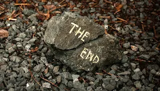 Two grey rocks on the ground with the words "The End" painted on them.