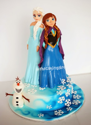 beautiful elsa and anna figurines on cake