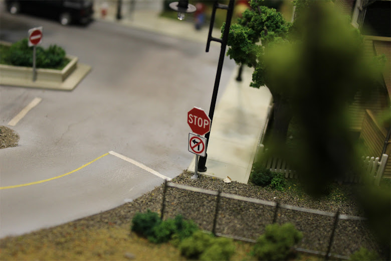 Detailed view of a stop sign and no left turn sign installed at an intersection in a downtown scene