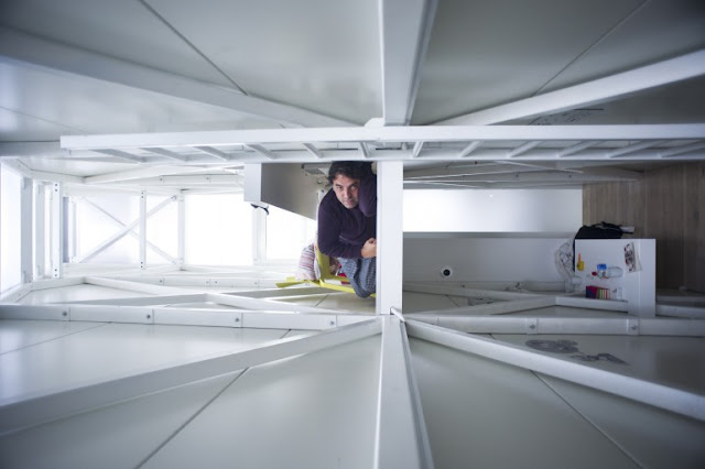 Picture of Keret in his narrow house as seen from the ceiling