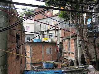 Dripping electrical wires criss-crossing in front of the multi-storied structures within the favela.