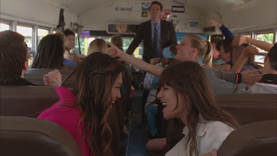 Rachel and Tina finishing up their song together on the bus surrounded by their friends as they prepare to head to Nationals