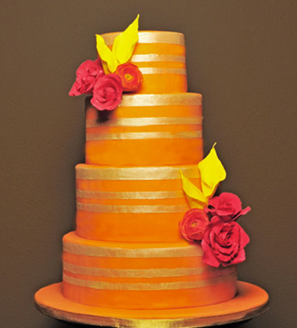 A stunning four tier wedding cake with pink roses and yellow calla lilies