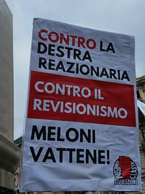 Cartello del gruppo "Sinistra Classe e Rivoluzione" (simbolo di un pugno chiuso rosso) che recita: Contro la destra reazionaria contro il revisionismo Meloni vattene