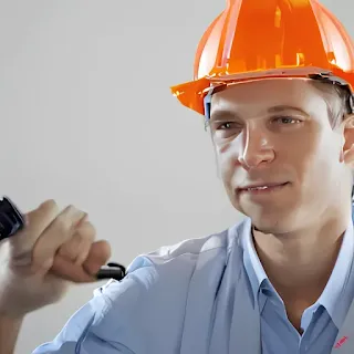 Engineer man with Orange construction hat on his head wearing a suite with tool in his hand