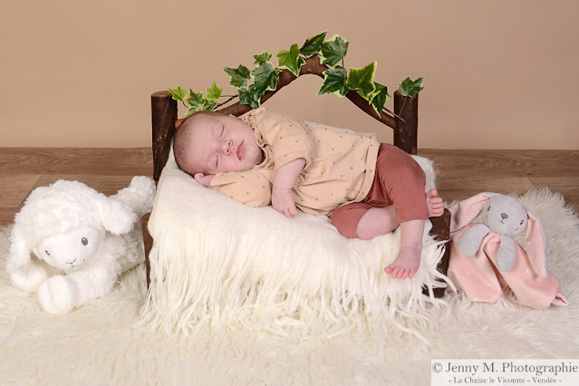 portrait bébé sur petit lit en bois avec doudou et plaid en laine