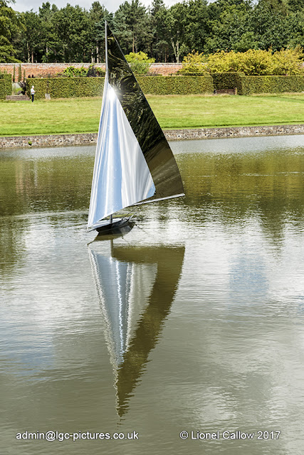 This is a stainless steel sculpture of a yacht. It is mobile with the wind floating on the lake.