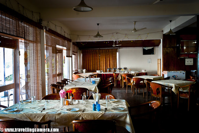 During beginning of this year, I visited Dharmshala for covering finals of Cricket Mahasangram and HPCA(Himachal Pradesh Cricket Association) had arranged for stay in Dhauladhar Hotel, which is just in the middle of Dharmshala Market.This is a view of backside where Dhauladhar Hotel has some open dining area with wonderful view to the valley !!I took Volvo form Delhi and reached early in morning. Dhauladhar Hotel is at walkable distance from Bus stand but since I had more stuff to carry, so got a taxi at very reasonable tariff (50 Rs :) )I entered into the room and it was decent, although very old. Personally I am not very choosy unless things are not neat and well placed. So I found this room a good place to stay for me. Service was also good, although I had an extra advantage of being able to speak in Himachali ! I loved the woodwork there. I have heard of Kangra Suite in this hotel which is considered as best place.Here is a view of some colony from open dining area of Dhauladhar Hotel in Dharmshala !!! This hotel is approximately 4 kilometers far from Cricket Stadium constructed by Himachal Pradesh Cricket Association.Another view of a valley from Dhauladhar Hotel in Dharmshala, Himachal Pradesh, INDIA. Usually people prefer to stay in Mcleodganj as compared to Dharmshala Town.Hotel corridor which connect most of the rooms on second floor. The first suite on the right is Kangra Suite !!!This is back side of Dhauladhar Hotel in Dharmshala ! This could have been better maintained. There is enough space to make a garden as well !!!Another view of a valley from Restaurant of Dhauladhar Hotel in Dharmshala !!!Dhualadhar Mountain ranges are clearly visible from this hotel and people prefer to have their meals in open dining area !!!This is restaurant of Dhauladhar Hotel, which can be seen empty most of the times. It's not that people don't visit, but people prefer to sit in open dining area.There is a small parking area in front of main entry of Dhauladhar hotel, but it seems currently residents of Dharmshala use it in better way :)Here is another corridor in Dhauladhar Hotel, Dharmshala. Monkeys can be seen in these corridors as whole area is not very well closed. So they enjoy walking inside this hotel to see different types of tourists !!! Soon after checking in at Dhauladhar, I had to reach stadium. I thought of walking down to the stadium and few gentlemen offered me lift but I wanted to see other things on the way. Photograph above shows dense Dharmshala town where everyone want to live !!!A photograph of road going down towards HPCA cricket stadium. Dharmshala market is mainly spread around this road only. There are some main offices are also on the way to stadium !!!Another view of Dharmshala valley full of colorful houses !!!Another HPTDC hotel in Dharmshala Market !!Roads are really well maintained inside the town. Overall roads in Himachal Pradesh are far better than what we daily see in Noida.Here is last colorful photograph from Dharmshala !!! Overall stay at Dhauladhar Hotel was good and I love HPTDChotel.