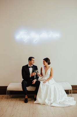 bride and groom with neon sign