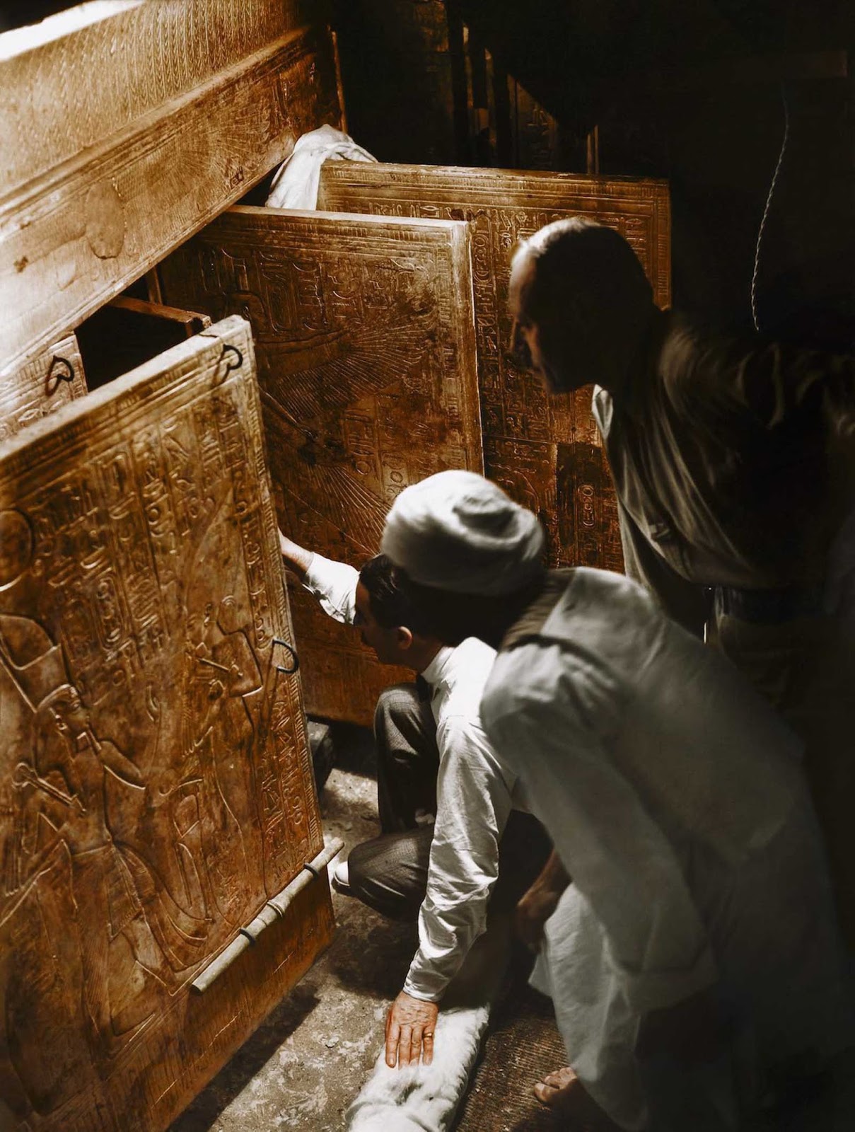 Howard Carter, Arthur Callender and an Egyptian worker open the doors of the innermost shrine and get their first look at Tutankhamun's sarcophagus.