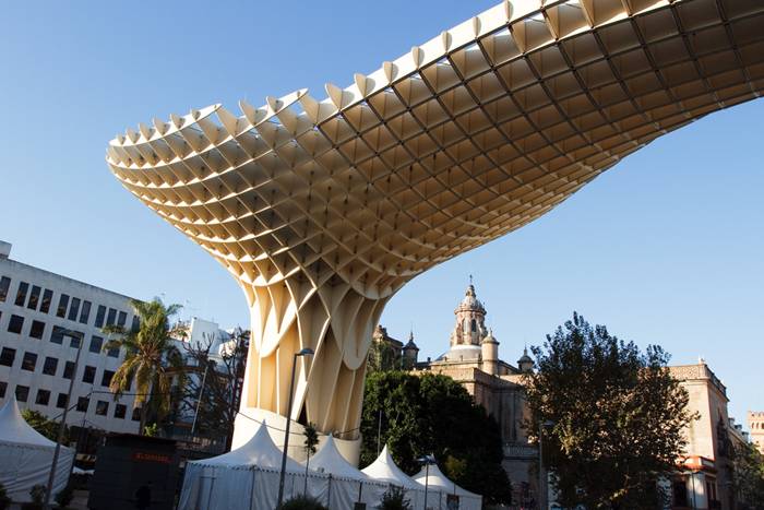 Metropol Parasol is a wooden structure located at La Encarnación square, in the old quarter of Seville, Spain. Designed by German architect Jürgen Mayer-Hermann, the structure resembles a grove of prefabricated wooden trees soaring 26 meters into the air. It has dimensions of 150 by 70 metres and claims to be the largest wooden structure in the world. 
